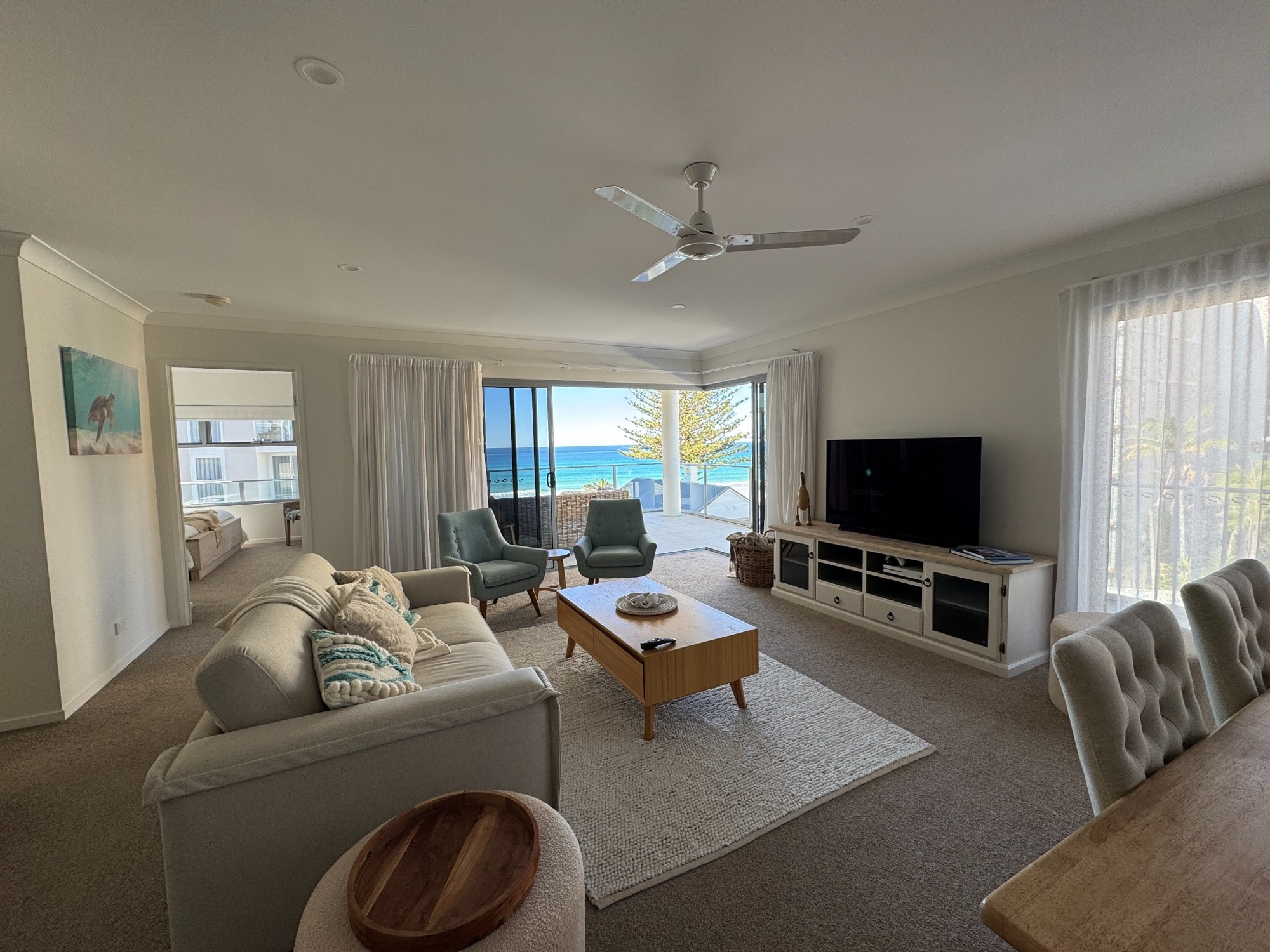 Apartment living area opening onto the balcony with ocean views